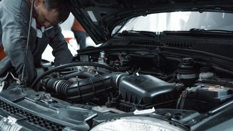Mechanic inspecting a car engine during routine maintenance