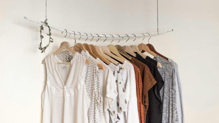 Neutral clothes on wooden hangers for a capsule wardrobe