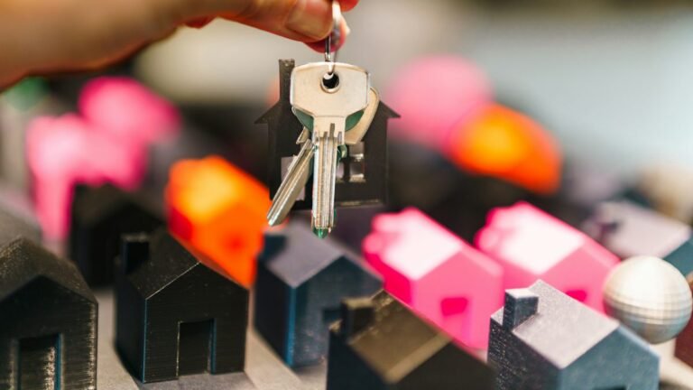 House keys held above miniature model houses