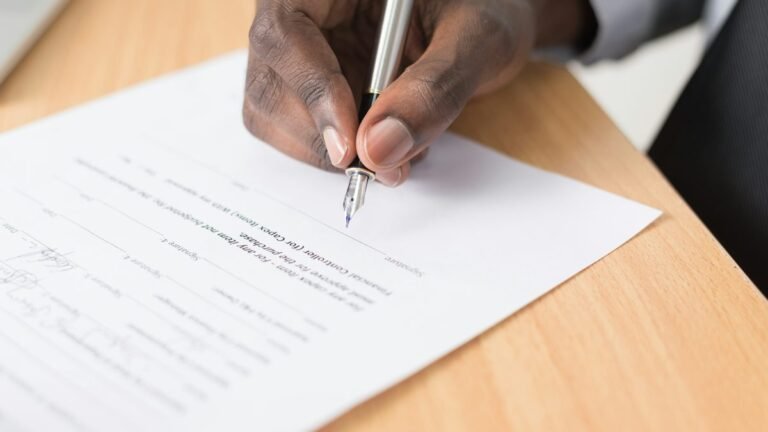 Person reviewing and writing on a lease agreement document